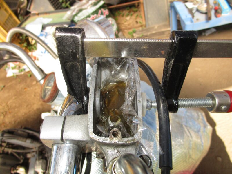 ホンダ・ジョーカー90 ディスクブレーキのブレーキフルード液確認窓の交換　Fクランプを使用して窓の圧入をしている画像
