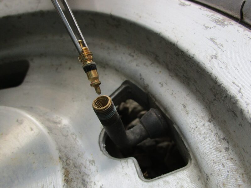 タイヤのエアバルブ部のコアバルブを、ピンセットを付けって取り外した画像