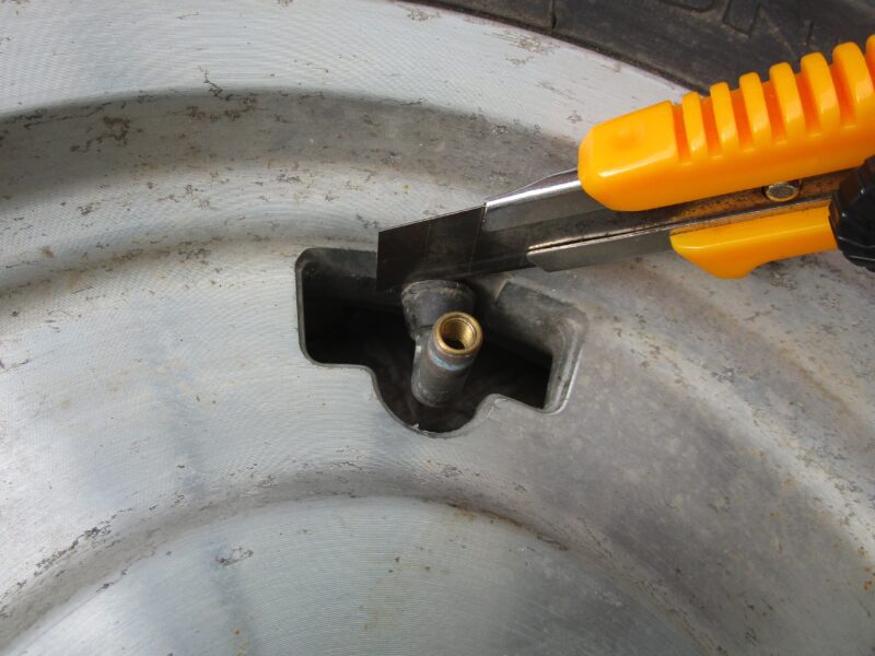 タイヤのエアバルブの取り外し方①エアバルブの根元をカッターで切断している画像