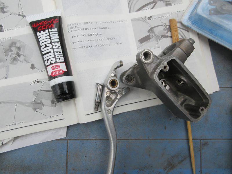 ブレーキレバーのピボット部にシリコーングリース（KURE GREASE MATE）を塗布する様子