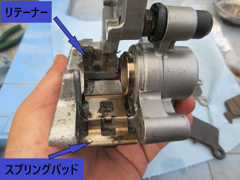 キャリパー本体にリテーナーとスプリングパッドを取り付けた位置と方向を示す写真